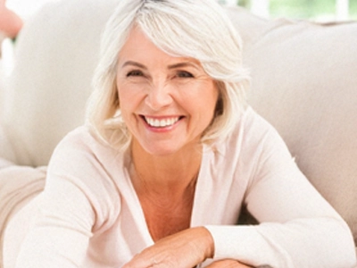 65 year old lady lying on her front with white hair and a warm smile. She's a GILF!
